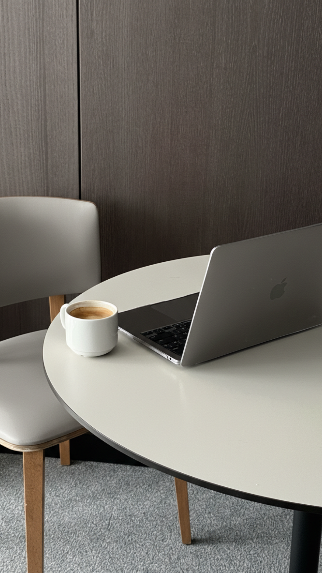 Laptop and coffee on a round table, ready for a working session